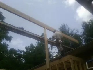 Carpenter setting a ridge beam over a new addition frame — Ice Dam Removal by Roofing Brothers in Maidens
